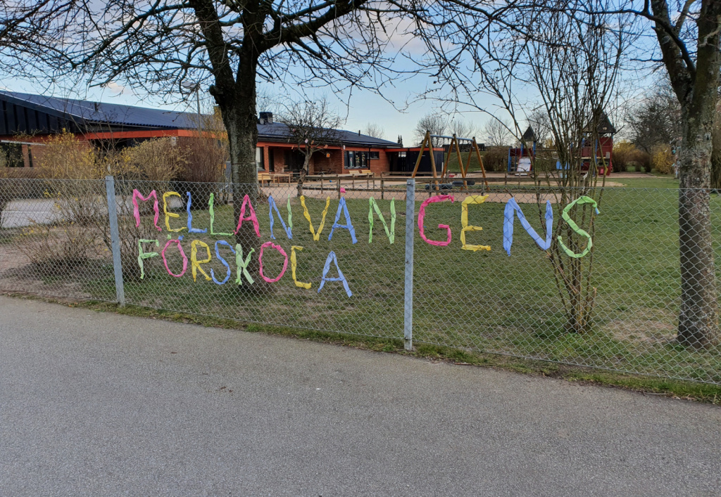 Text med Mellanvångens förskola flätat med texil på gårdens staket.