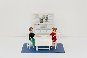Två dockor som sitter vid ett bord