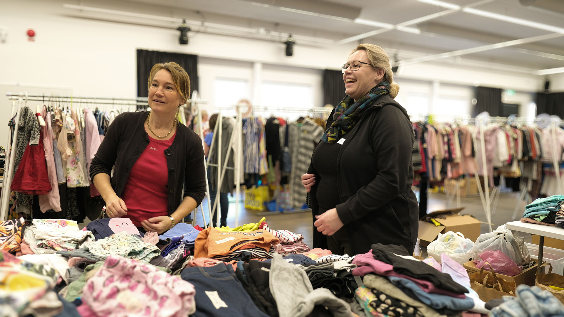 Anneli Oddsson, sekreterare i föreningen och Anna Plato, kassör, viker och sorterar några av alla kläder som kommit in till loppisen.