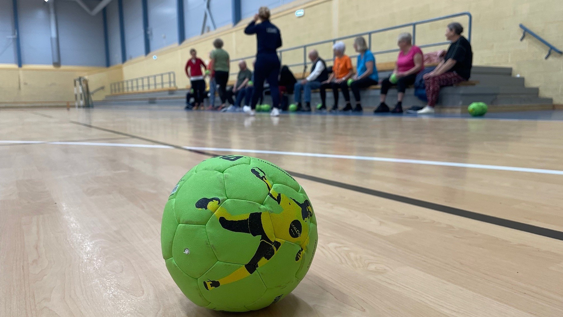 En handboll framför en grupp pensionärer