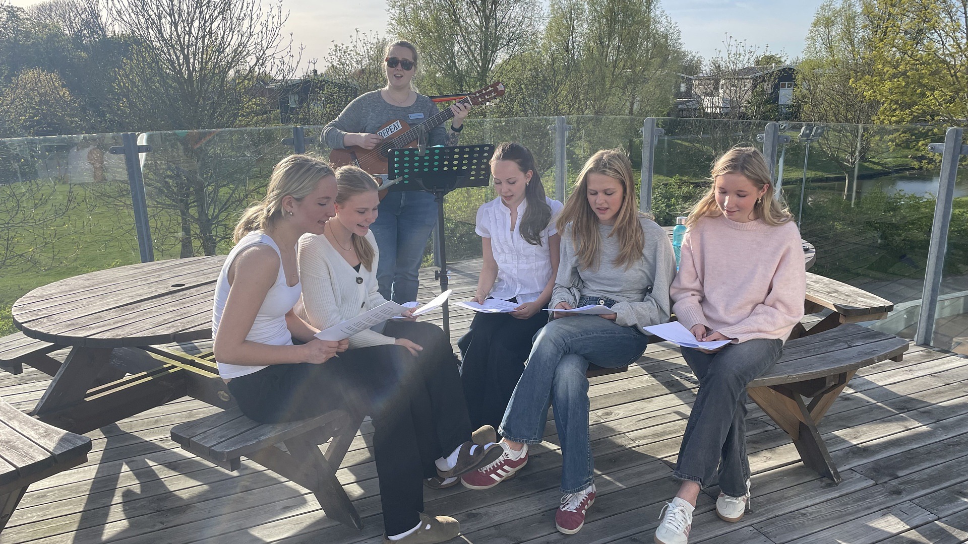 Elever sjunger på en balkong. Foto.