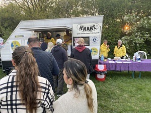 Folk framför korvvagn.