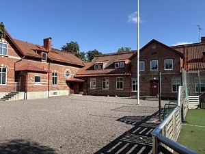 Tottarps skola i rött tegel, och fönster med vita ramar.