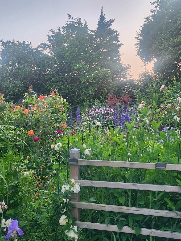 EN prunkade trädgård med blommor, växter och träd.